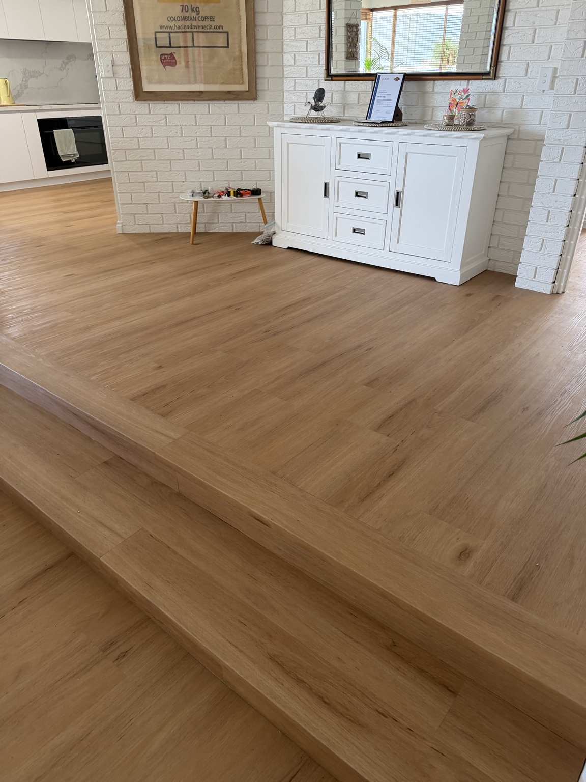 Vinyl plank flooring with angled step edging around a raised living area