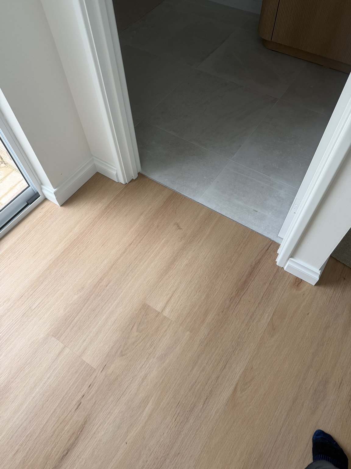 Vinyl plank meeting existing tile flooring at a doorway